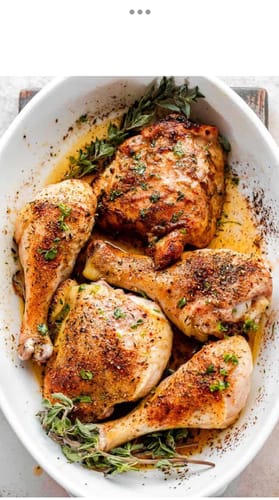Reviewer's roasted chicken pieces seasoned with herbs in a white baking dish.