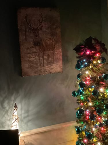 Customer's Vintage Winter Deer wall art hanging on a wall next to a decorated Christmas tree.
