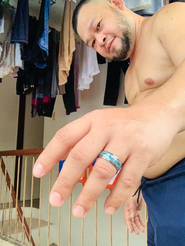 A reviewer's hand showing the fit of the Vanguard ring with a silver band and blue inlay.