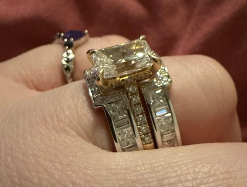 Customer's customized XR2498 ring set, shown from a side angle on their finger, with a smaller ring visible behind it.