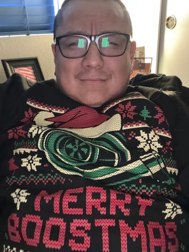 Reviewer wearing the black MERRY BOOSTMAS CHRISTMAS SWEATER with its festive turbo design.