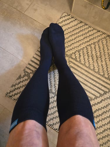 Customer's point-of-view showing their legs and feet in dark Performance Eucalyptus Compression Socks.