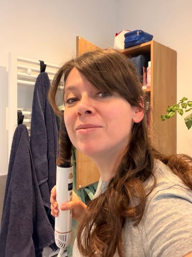 Recensent die de witte SANSBEAUTÉ® 8-IN-1 AIRSTYLER gebruikt om een krul in haar haar te maken.