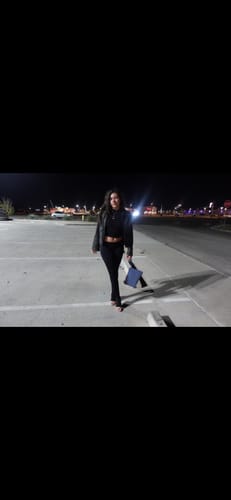 Customer wearing the black Seamless LowRise Legging with a crop top and jacket in a parking lot at night.