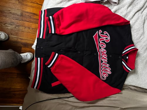 Customer's custom black and red varsity jacket laid out, showing the 'Roseville' script on the front.