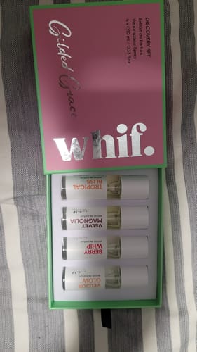 Reviewer's open Gilded Grace discovery set box, showing four small perfume vials arranged inside.