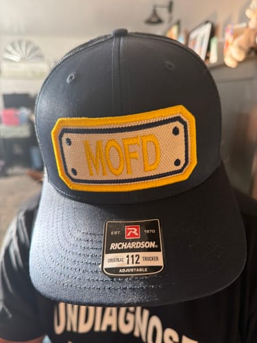 Customer's black SNAPBACK HOSE HAT with a Richardson sticker on the brim and a yellow 'MOFD' patch.
