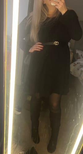 Reviewer takes a mirror selfie wearing the Mandy Black Cold Shoulder Knit Dress with a belt and tall boots.
