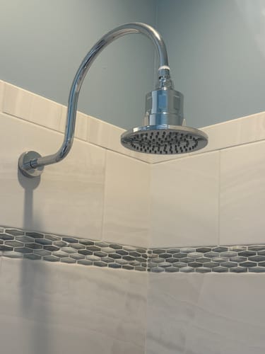 Customer's shiny Gillian Filtered Shower Head installed in a tiled shower.