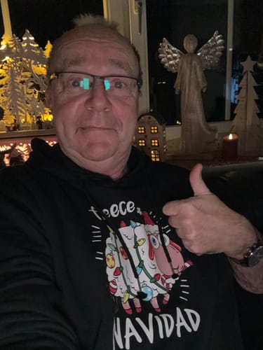 Kunde trägt den schwarzen Fleece Navidad Schaf Hoodie und gibt einen Daumen hoch.