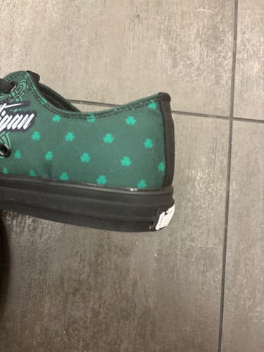 Close-up of a reviewer's green Hooligan Low Top, showing the heel and black sole with visible glue.