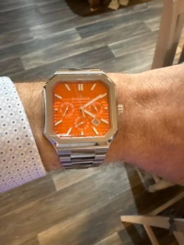 Reviewer wearing the Oceaneva Tenuis Automatic watch, showcasing its bright orange dial on their wrist.