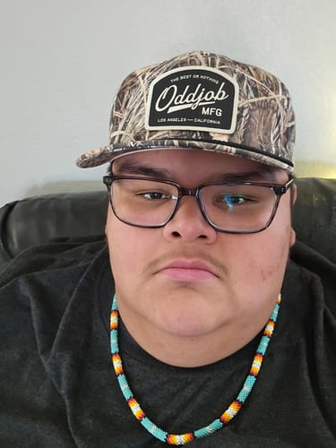 Reviewer showing the fit of the Big Unstructured A-Frame Hat in a camouflage pattern.