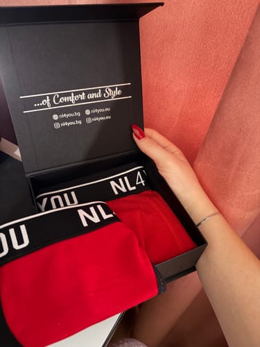 Customer opens a black branded box to reveal two pairs of red and black cotton boxers.