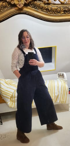 Une cliente se photographie dans un miroir pour montrer la coupe ample de la salopette Isaure marine.