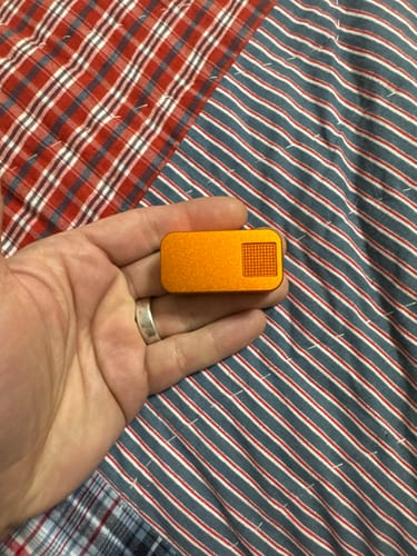 Customer holding the small orange Nano Pill Case in their hand to show its size.