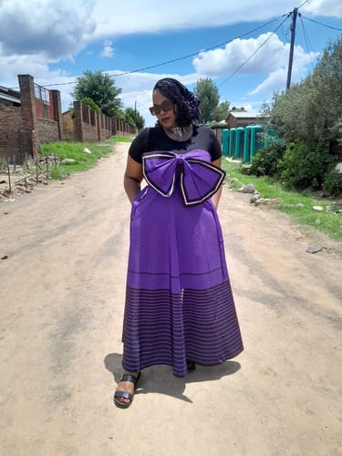 Reviewer wearing the purple Traditional Maxi Skirt and Ribbon Design Top over a black t-shirt outdoors.