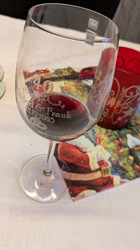 Rezensent zeigt das personalisierte Leonardo Weinglas für die Rubinhochzeit, gefüllt mit etwas Rotwein.