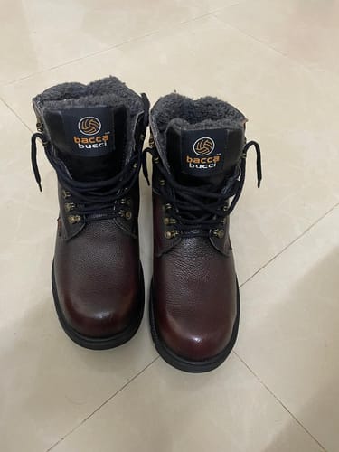 Customer's pair of brown leather Bacca Bucci snow boots with a thick fur lining, seen from the front on a tile floor.