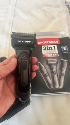 Customer holding the Sportsman 3-in-1 Grooming Kit with the product box visible in the background.