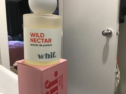 Customer's frosted glass bottle of Wild Nectar perfume sitting on top of its pink product box.