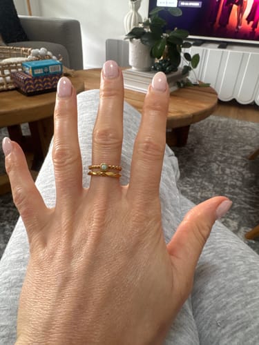 A reviewer's hand wearing the gold-colored Double Layer Stone Ring on their finger.
