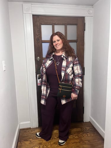 Reviewer wearing the majestic purple Luca Ribbed Pants and a matching top, styled with a plaid jacket.