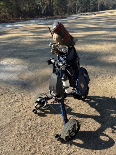 Reviewer's blue Cybercart with a golf bag, shown from a side angle on a golf course.