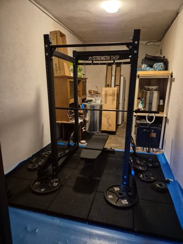 Customer's Heavy Duty Home Gym Bundle with the black Riot MRR Rack and utility bench set up in a home gym.