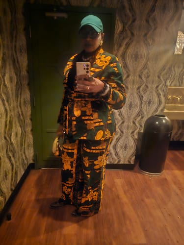 Reviewer taking a full-length mirror selfie, showing the fit of the ZYLA AFRICAN PRINT SUIT SET in a stylish room.