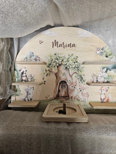 Rezensent zeigt das personalisierte Toniebox-Regal aus Holz mit einem Waldmotiv und dem Namen 'Marina'.