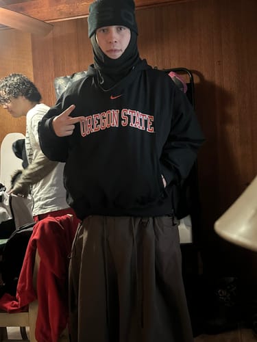 Reviewer showing the baggy fit of the coffee Drawstring Balloon Snow Pants indoors.