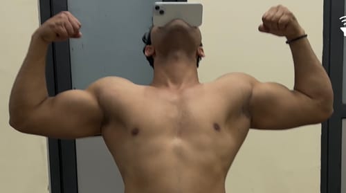 A reviewer flexing their muscular biceps, showing results from using YouWeFit Omega-3 Fish Oil.