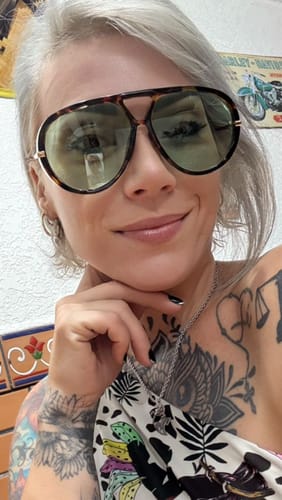 Cliente usando os Óculos Tropea com armação tartaruga estilo aviador e lentes esverdeadas.