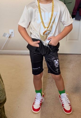 Customer's son wearing the black 'Lion' Youth Performance Shorts, showing the lion graphic and scripture on the legs.