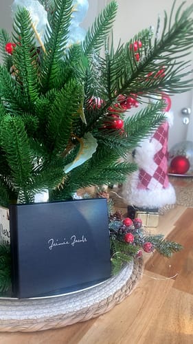 Customer's black packaging for the Flap Boy Slim wallet, displayed in front of a small Christmas tree.