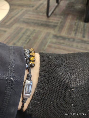 Customer wearing the Guardian Tiger's Eye bracelet as an anklet over a black sock.