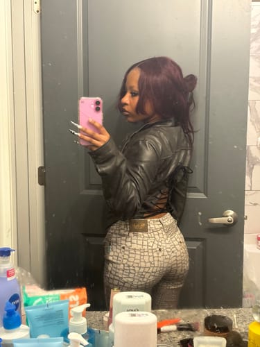 Reviewer from the side wearing The Villain Moto jacket, showing the adjustable laced-up back detail in a mirror selfie.