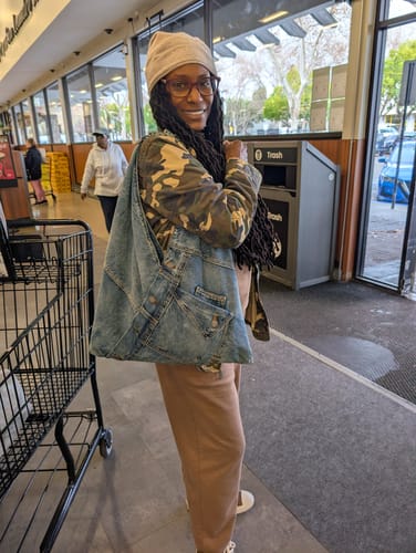 Reviewer in a store with their Denim Shoulder Bag, which is styled to look like jeans.