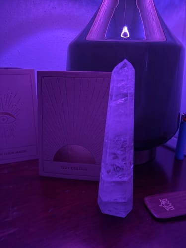 Reviewer's lovely Crackle Quartz Tower standing on a wooden surface, bathed in purple light.