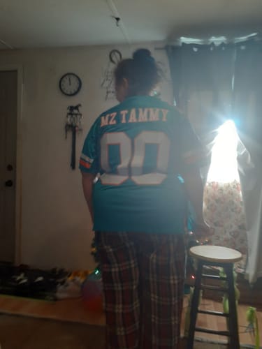 Reviewer from behind wearing the custom aqua football jersey with 'MZ TAMMY' and the number '00' on the back.
