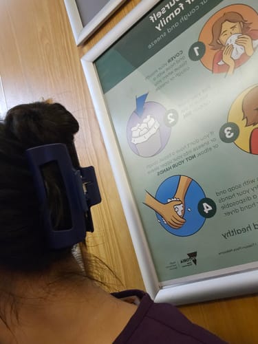 Reviewer showing the navy blue cloud clip holding up their thick hair at work.