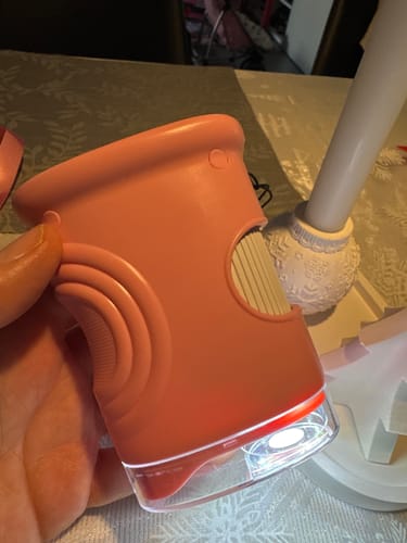 Rezensentenhand hält das beleuchtete, pinke Spielzeugmikroskop aus dem Edubini Outdoor Suchspiel.