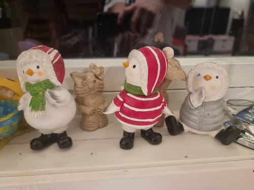 Kundens tre julefugler i vinterklær plassert på en hvit vinduskarm.