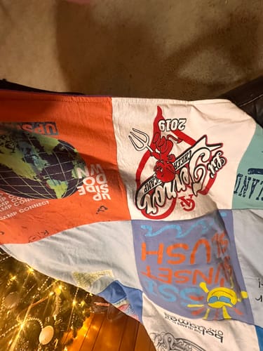 Close-up of a customer's Premium T-Shirt Quilt featuring a red devil mascot patch for "St. Simon's Cheer Camp 2019".