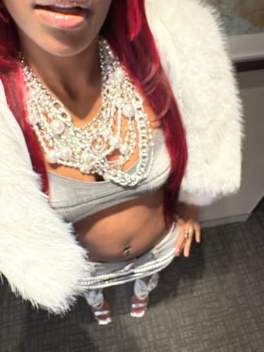 Close-up of a reviewer wearing the grey Denim Bra with a chunky necklace and white jacket.