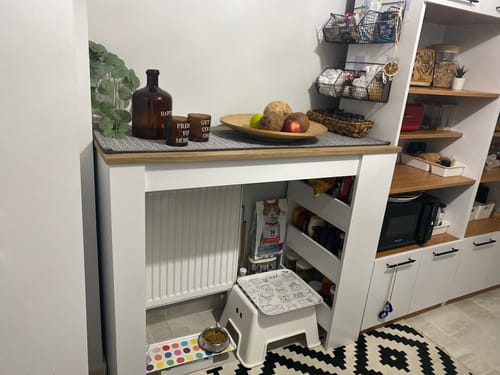 Müşterinin mutfağına kurduğu, beyaz ve ceviz renkli Rani JA103 bar masası. Rafları ve üstü eşyalarla dolu şekilde görünüyor.