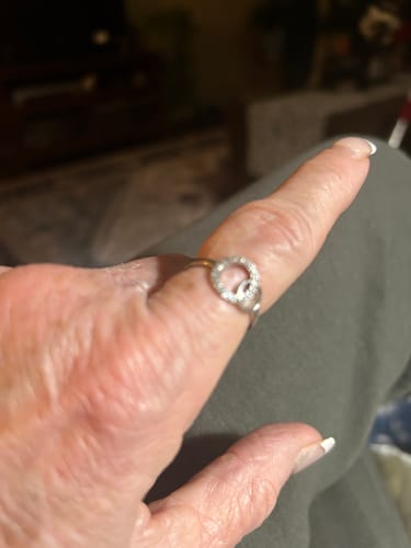 A close-up of a customer's hand wearing the sparkling silver Forever Linked Ring on their index finger.