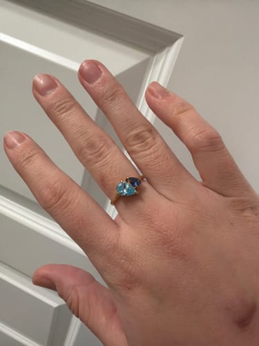 Customer wearing the Leesha Birthstone Ring, showing the two shiny pear-cut birthstones in light and dark blue.