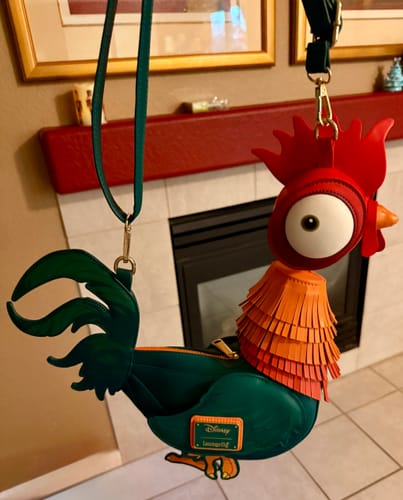 Customer's Loungefly Disney Moana Hei Hei figural crossbody bag held up, showing the full rooster shape and colorful details.